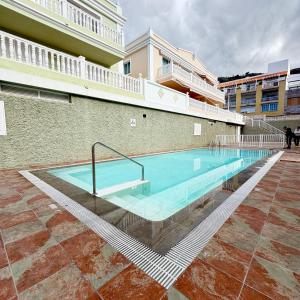 a large swimming pool next to a building at Apartamento Wanda junto al MAR in Puerto Naos