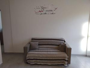 een bed met een deken en een bordje aan de muur bij Appartamento AchiRosa in Verbania +36 foto's