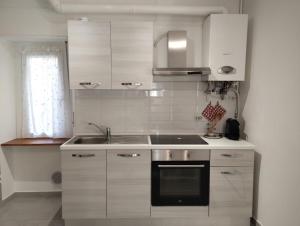 韦尔巴尼亚Appartamento AchiRosa的带水槽和炉灶的白色厨房