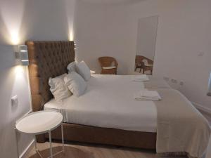 a bedroom with a large white bed and a table at CITY STAYS BELÉM APARTMENTS in Lisbon