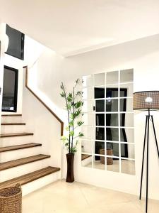 una sala de estar con escaleras y una planta en un jarrón en NEW Exclusive Luxury Pool Villaa, en Lapu Lapu City
