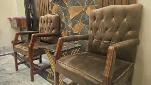 two chairs and a table in a room at Hotel Moon Light in Karachi
