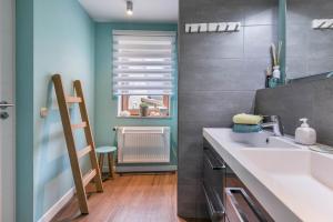 a kitchen with a sink and a window with a radiator at Gästehaus zwischen Meer und Wald in Schiedenhohlweg +18 photos