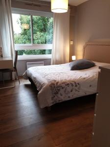 a bedroom with a bed in front of a window at Appartement 115 m2 Garage Tram Lille St Maur in Lille