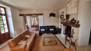 a living room with a couch and a fireplace at Le Maine au bois in Saint-Vallier