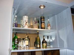 a shelf filled with lots of bottles of alcohol at Joe Apartman Budapest in Budapest