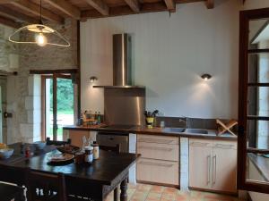 a kitchen with a table and a stove top oven at Le Maine au bois in Saint-Vallier