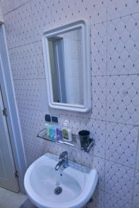 ein Badezimmer mit Waschbecken und Spiegel in der Unterkunft Appartement moderne 3 chambres au centre-ville de Kinshasa in Kinshasa