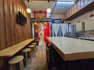una cucina con bar e sgabelli in un ristorante di Little Home in Town a Ban Lo Long