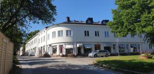 Un edificio blanco con un coche aparcado delante. en Studio Arkadia, modern studio with separate kitchen room, incl parking, en Porvoo