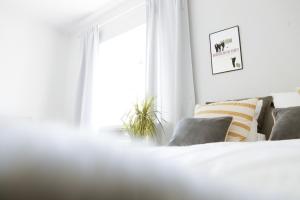 Un dormitorio blanco con una cama y una ventana. en Studio Arkadia, modern studio with separate kitchen room, incl parking, en Porvoo