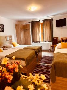 a hotel room with two beds and a television at Motel Stovrela in Cazin