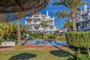 un complejo con piscina y palmeras en Luxury Duplex Sea Views La Cala Beach, en La Cala de Mijas