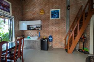 a kitchen with a staircase and a brick wall at Homestay Mộc Nhi in Hue