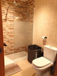 a bathroom with a toilet and a glass shower at Enjoy the beach in Bellreguart