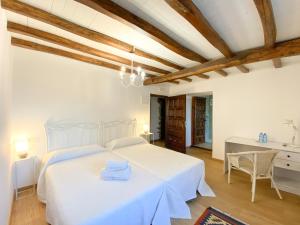 a bedroom with a white bed and a desk at Casa Pastur in Serantes