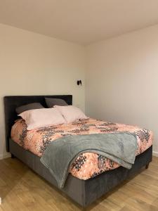 a bedroom with a large bed with a blanket on it at O2M Aix les bains in Aix-les-Bains