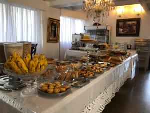 a buffet of food on a table with bananas and pastries at Colle Tourist Hotel Standard Sem Elevador in Criciúma