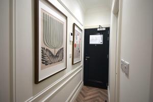 a hallway with two framed pictures and a black door at CITYeSCAPE - Studio 2 1 Bath Sofa bed NQ in Manchester +2 photos