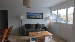 a living room with a couch and a table at Appartements Valognes in Valognes