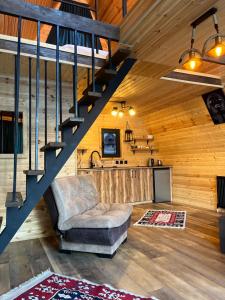 a living room with a staircase and a chair at Kazbegi Harmony Cottages in Kazbegi