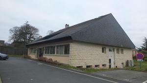 a building with a black roof on a street at Appartements Valognes in Valognes