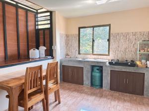 a kitchen with two chairs and a table and a sink at บ้านสวยกานต์ชนิต in Ko Yao Noi