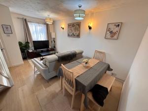 a living room with a table and a couch at Windsor & Legoland Stay, Slough & Free Parking - Berkshire in Burnham