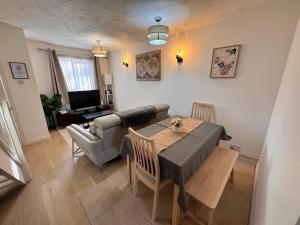 a living room with a table and a couch at Windsor & Legoland Stay, Slough & Free Parking - Berkshire in Burnham