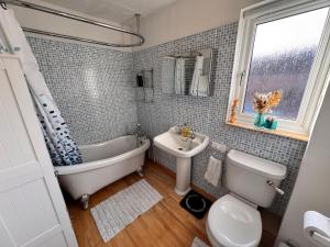a bathroom with a tub and a toilet and a sink at Windsor & Legoland Stay, Slough & Free Parking - Berkshire in Burnham