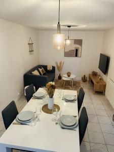 a living room with a white table and chairs at La pause Biardaise -Appartement 2 chambres à Biard in Biard