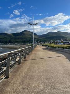 eine Brücke über einen Fluss mit Bergen im Hintergrund in der Unterkunft Betty's Cottage in Newcastle + 5 Fotos