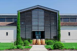a building with barrels in front of it at La Fleur de Boüard in Néac