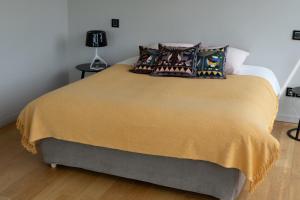 a bed with a yellow blanket and pillows on it at La Fleur de Boüard in Néac +5 photos
