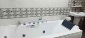 a white bath tub in a bathroom with a sink at Квартира Olimbe in Olembé