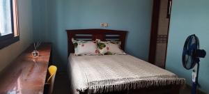 a bedroom with a bed with a wooden head board at Квартира Olimbe in Olembé