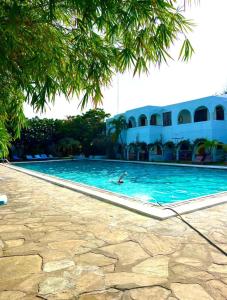 a person swimming in a swimming pool next to a building at Studio Leliya 2 in Malindi