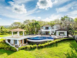 Una vista exterior de una casa con piscina. en The Point 5-Star All-Inclusive Experience, en Tamarindo