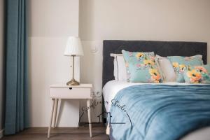a bedroom with a bed and a table with a lamp at Sunflower Studio in Braga