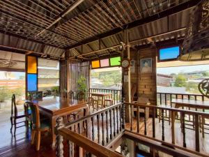 a dining room with a table and chairs on a balcony at โรงแรมเฮือนช้างเผือก Huen Chang Phueak in Nan