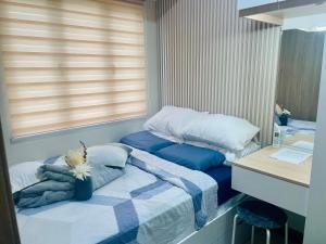 a small bedroom with two beds and a desk at Coast Residences condo near MOA, StarCity and PICC in Manila +14 photos