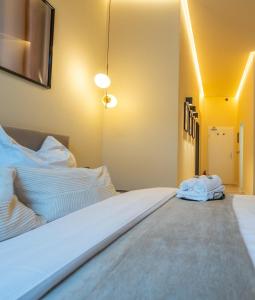 ein Schlafzimmer mit einem großen Bett mit weißer Bettwäsche in der Unterkunft LLR Design Apartment- Santal Blush im Zentrum von Koblenz in Koblenz