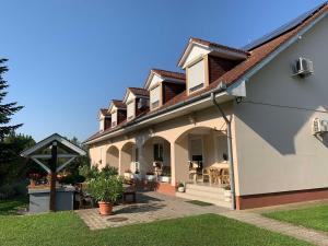 a large house with a patio and a yard at Panzió Pér in Pér