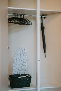 ein schwarzer Regenschirm und ein Korb auf einem Regal in der Unterkunft LLR Design Apartment- Santal Blush im Zentrum von Koblenz in Koblenz