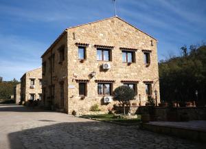 a large stone building with windows on a street at Agriturismo Borgo Furma in Enna