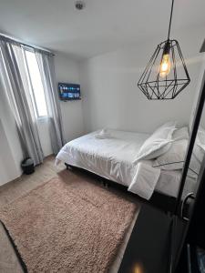 a bedroom with a bed and a chandelier at Habitaciones privadas cerca al aeropuerto in Armenia +3 photos