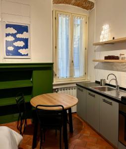 cocina con mesa de madera y fregadero en Sisters' Home, en Bérgamo