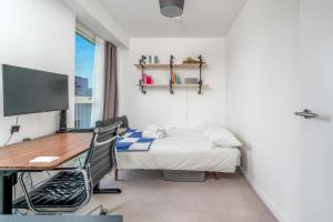 a bedroom with a desk and a bed and a desk and chair at Waterview apartments with ultra fast wifi close to Excel and O2, corporates and contractors welcome in London