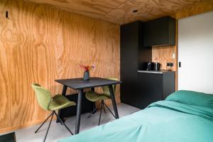 a bedroom with a table and two green chairs at Boshuisje Zelhem in Zelhem