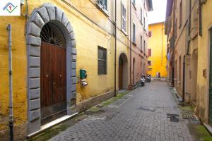 an alley with a brown door and a building at Tree House by TuscanyWeGo in Pisa